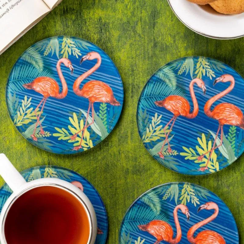 Close-up of round blue coasters featuring paired flamingos and leafy foliage