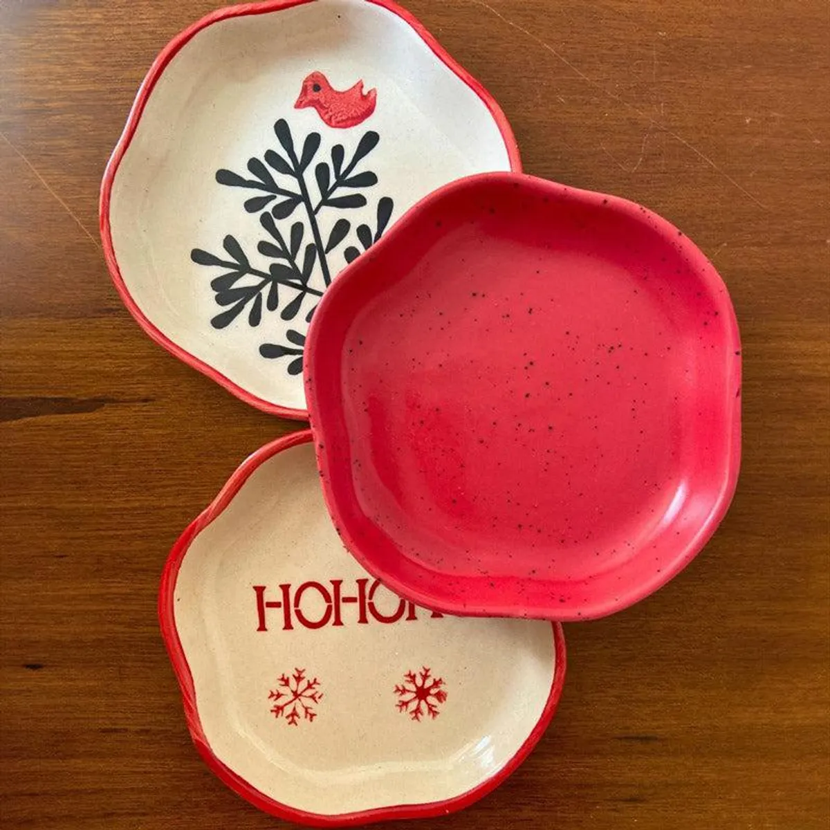Three festive ceramic platters arranged on a wooden table