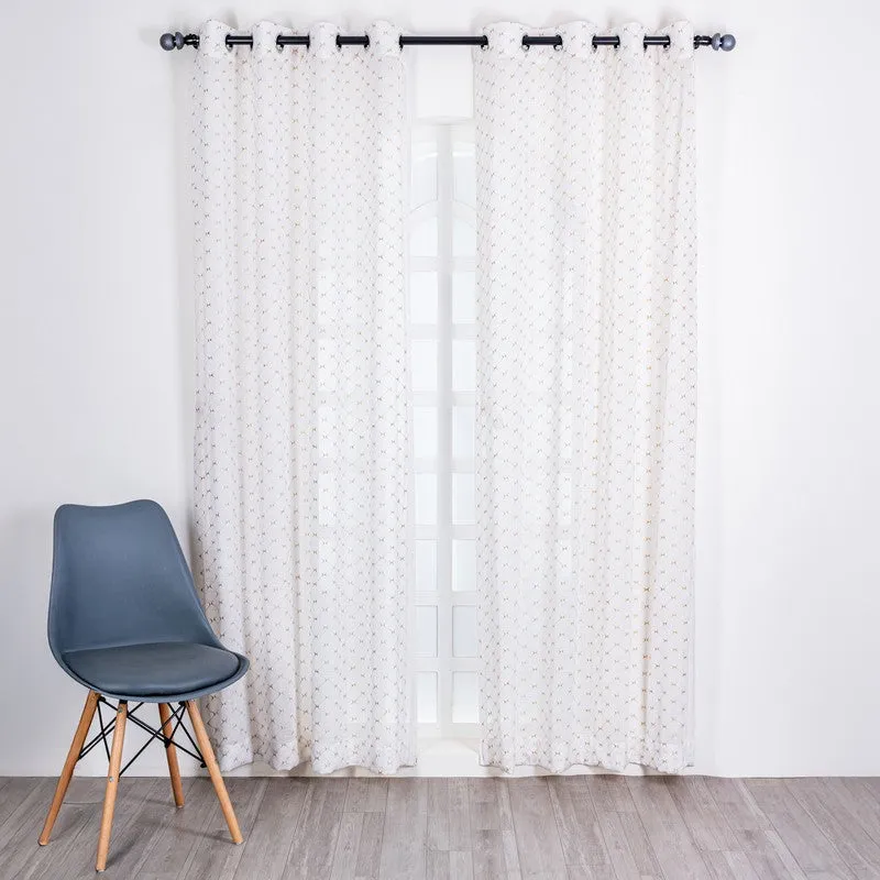 Gold-patterned sheer curtains hanging on a rod across a bright window