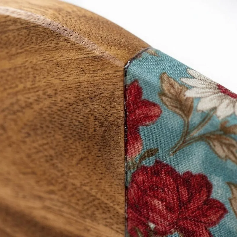 Close-up of mango wood grain beside the aqua-and-red floral platter detail