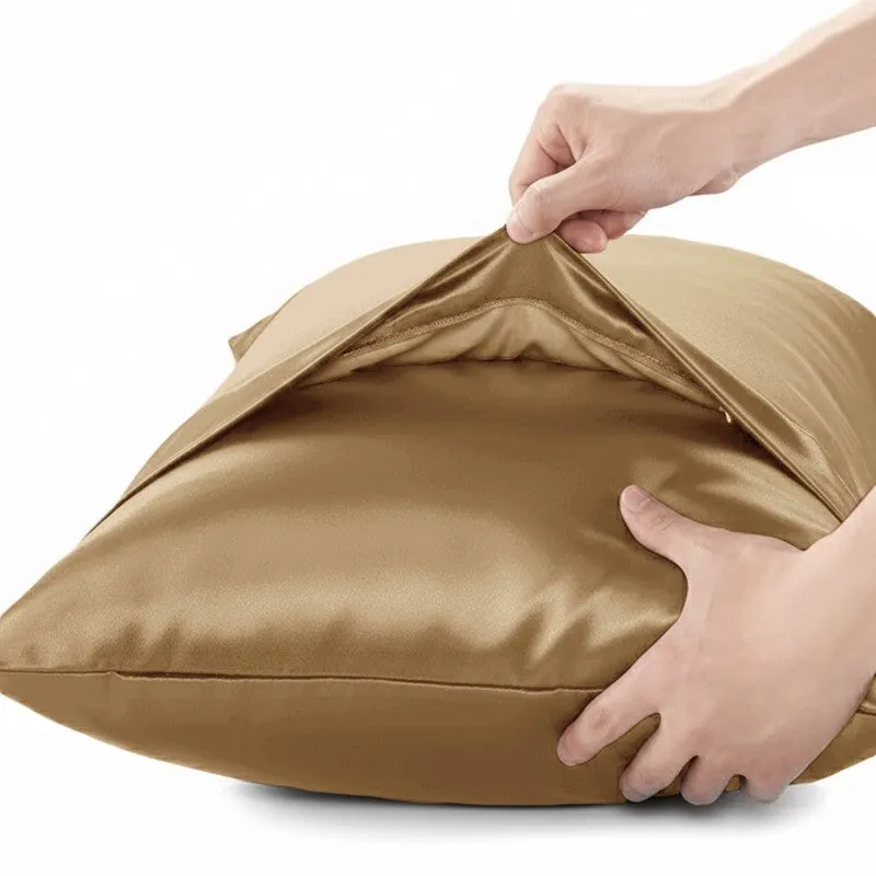 Hands opening a gold satin pillow cover to show its inner space.