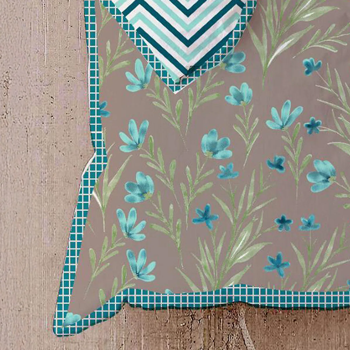 Close-up of blue flowers and green foliage on the beige floral dohar.