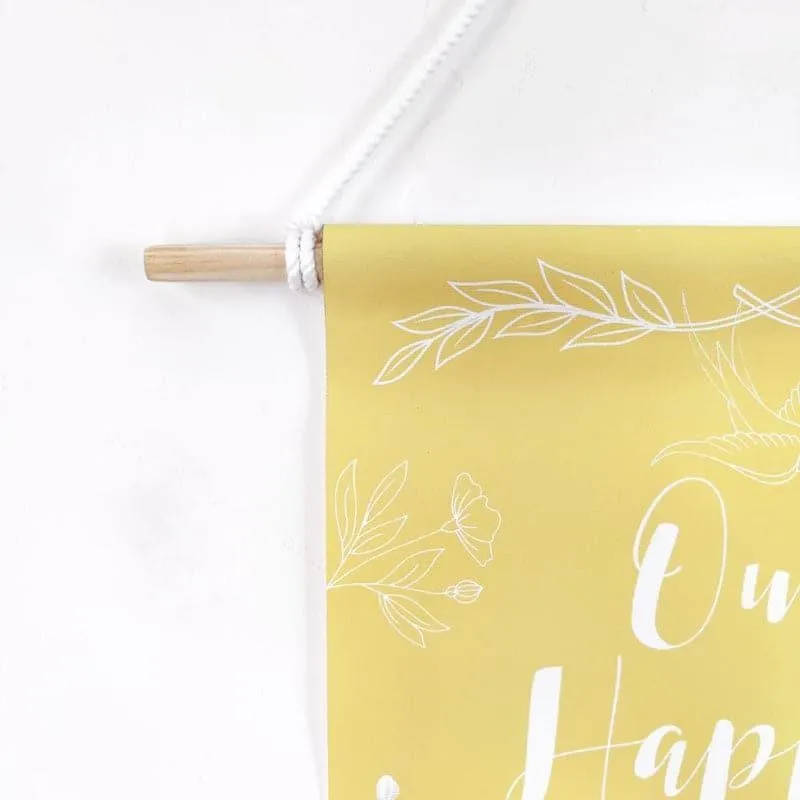 Close-up of yellow wall hanging with white floral detailing and hanging rod