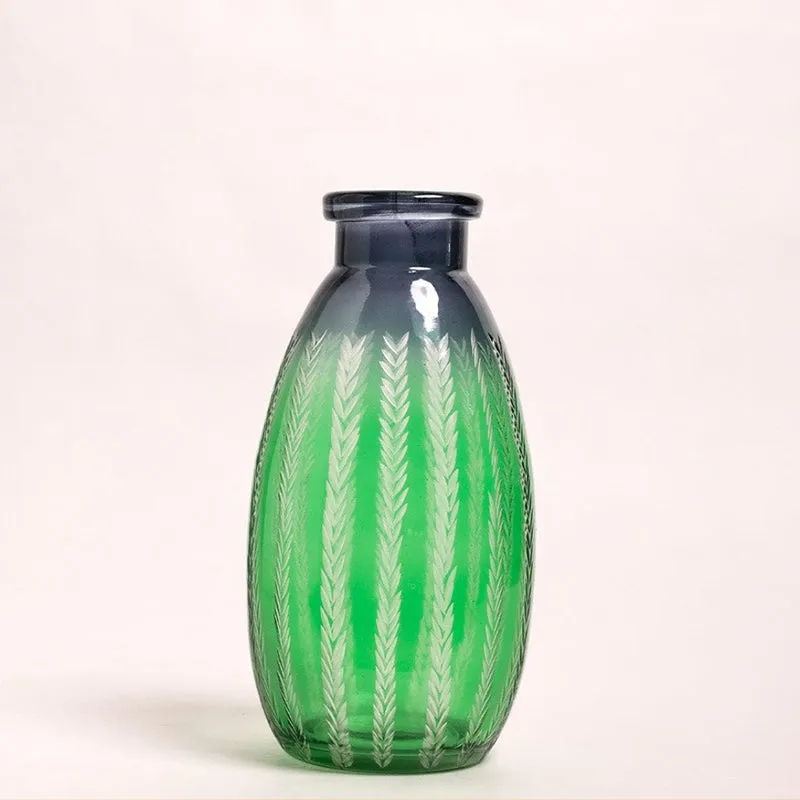 Front view of a green glass bottle vase with etched leaf detailing