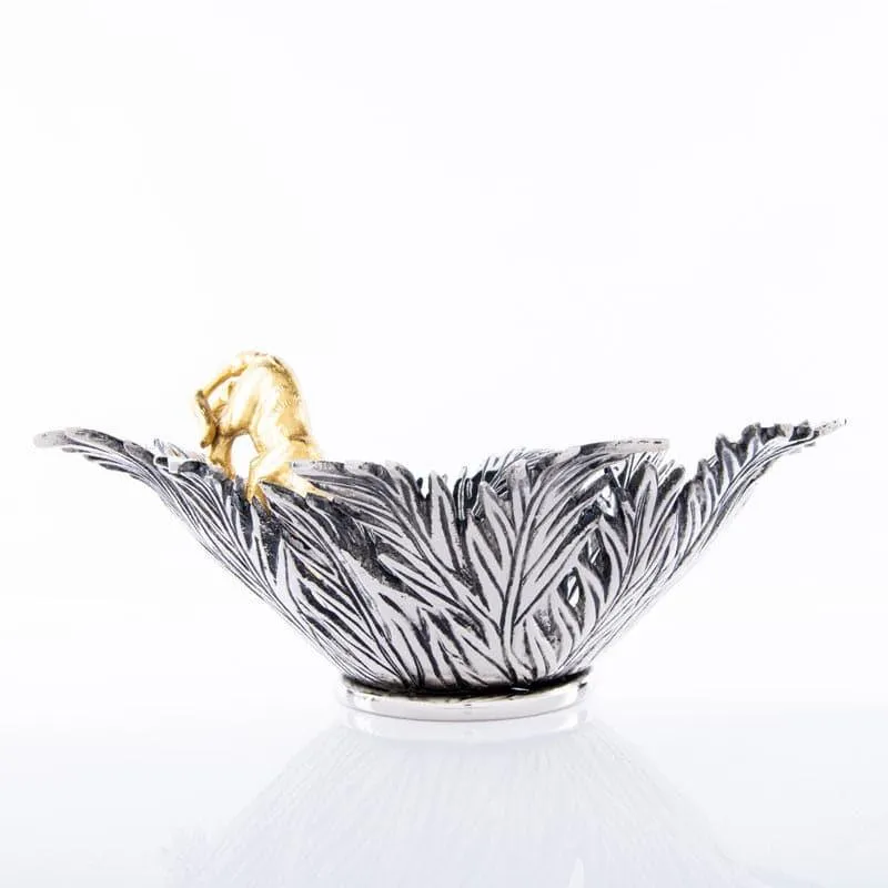 Side view of silver leaf-textured bowl with gold panther detail