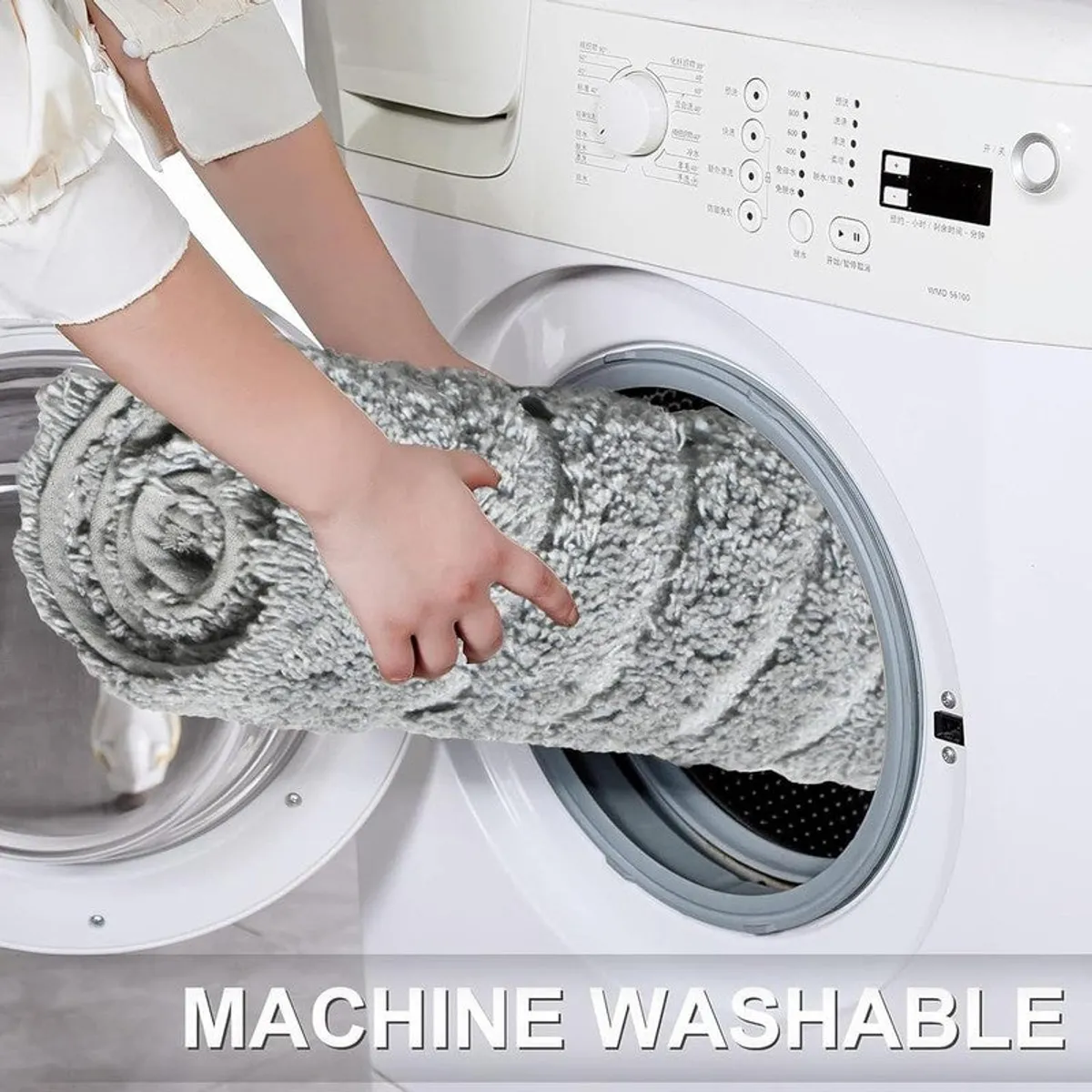 Rolled grey bath mat being placed into a washing machine