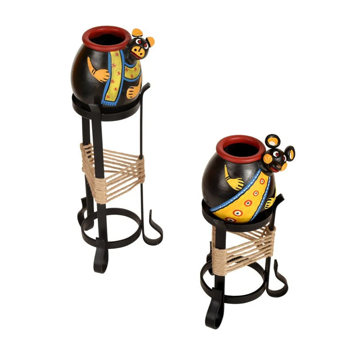 Angled view of two black tribal-style vases on metal stands