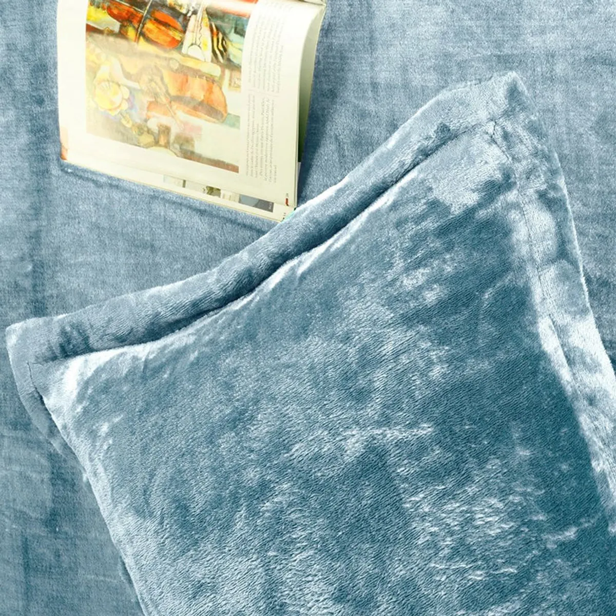 Sky blue velvet pillow cover placed on the matching bedsheet