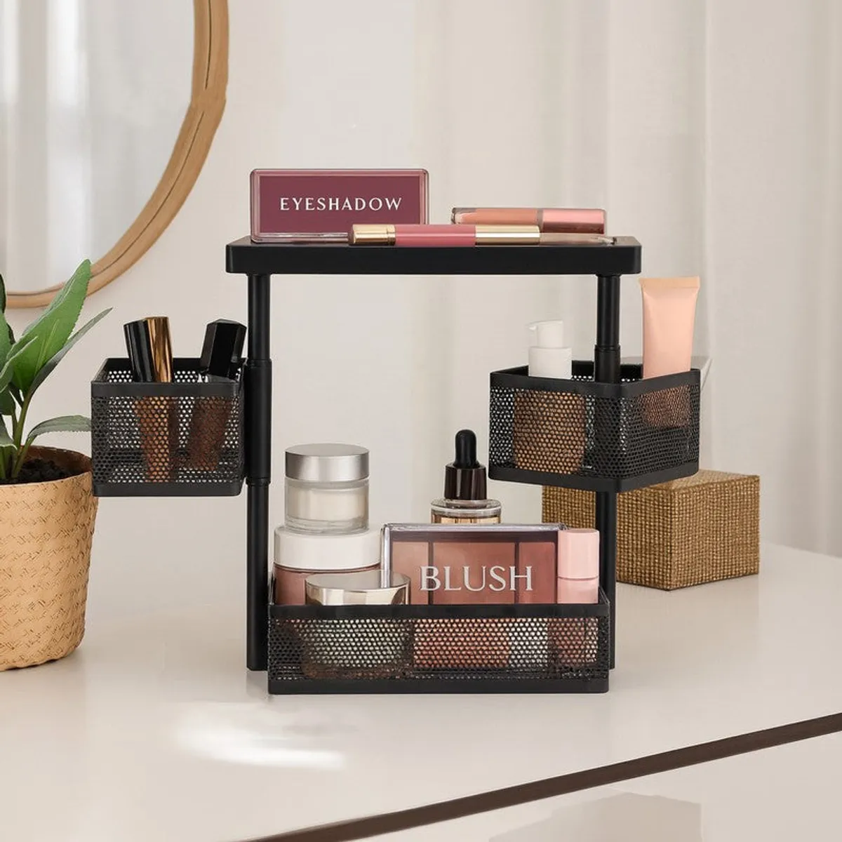 Black three-tier countertop organiser with baskets holding makeup and toiletries