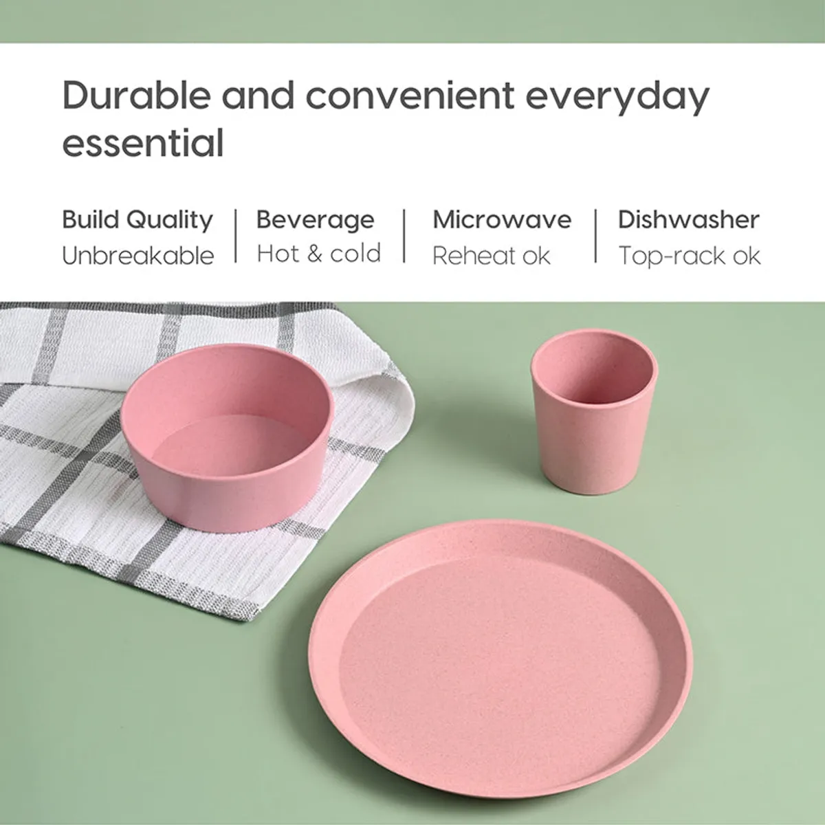 Pink bowl, cup and plate arranged on a green background