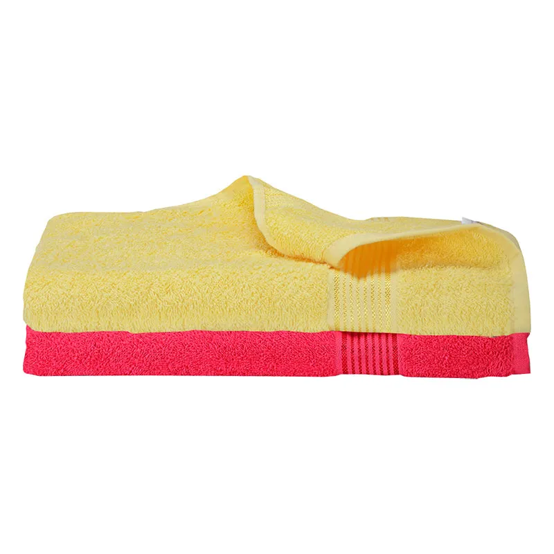 Folded yellow and red plush bath towels against a white background