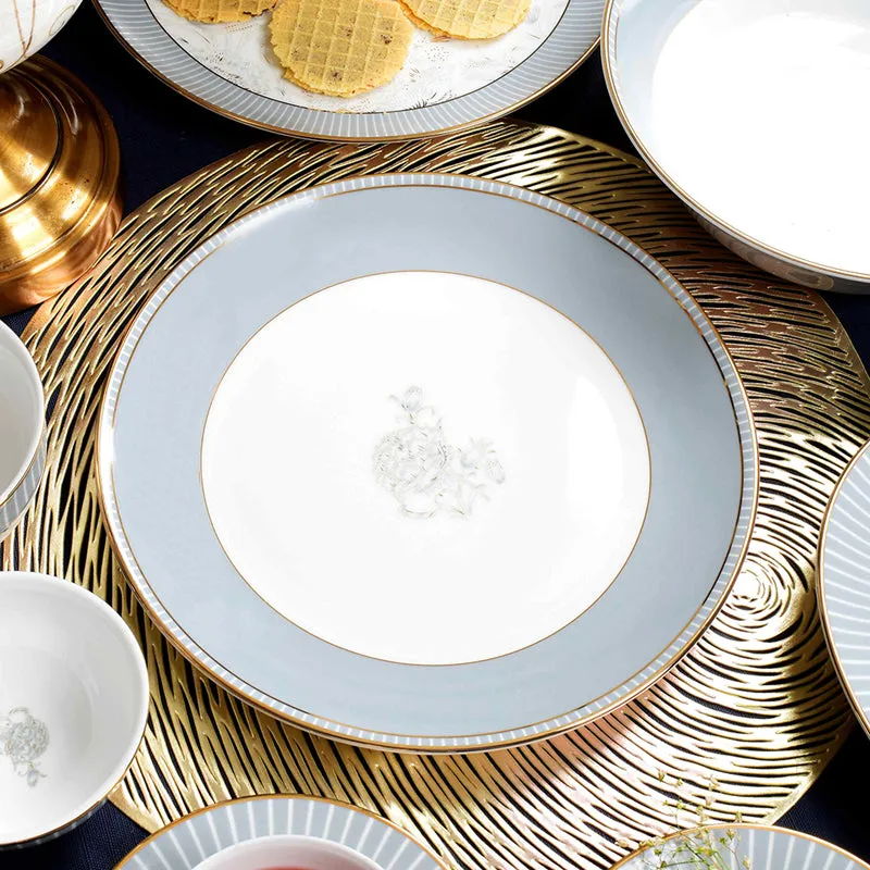 Close-up of a grey dinner plate with a white centre, floral motif and gold rim