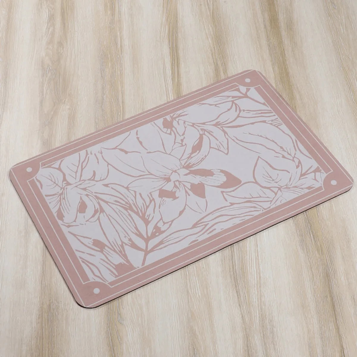 Peach floral bath mat displayed on a light wood floor.