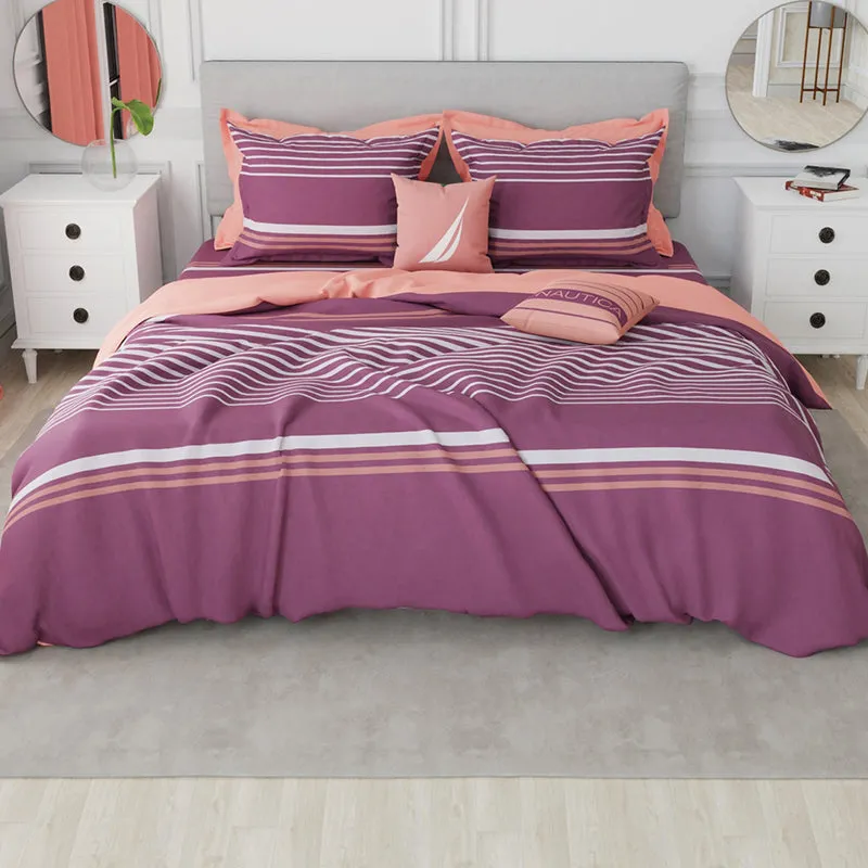 Bedroom styled with maroon striped bedding and peach accents