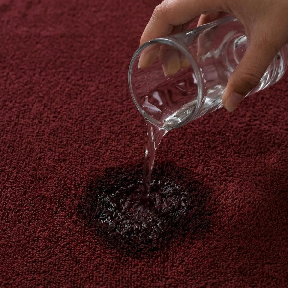 Water being poured onto the absorbent textured surface of a brown towel
