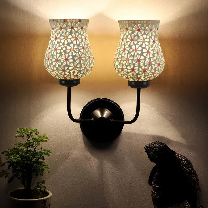 Twin mosaic glass wall lamp glowing warmly on a wall