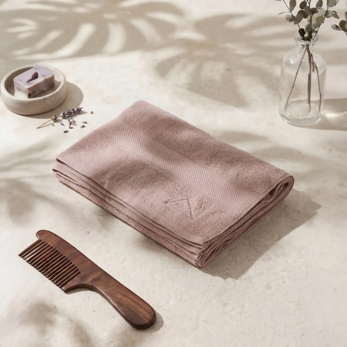 Folded beige bath towel styled on a tabletop