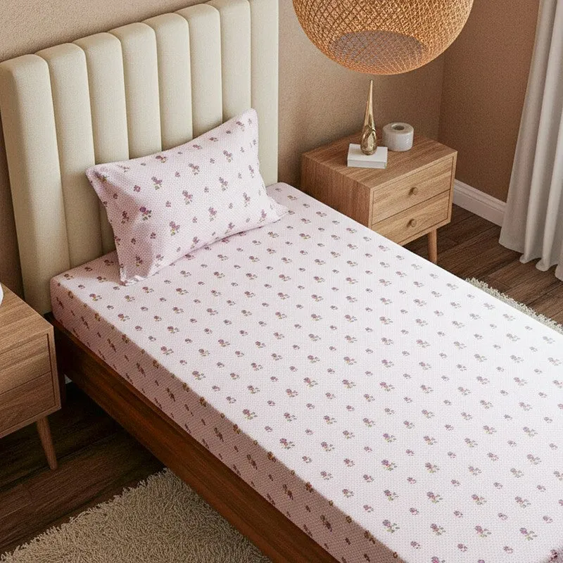 Close view of pink floral bedsheet and matching pillow cover on a bed