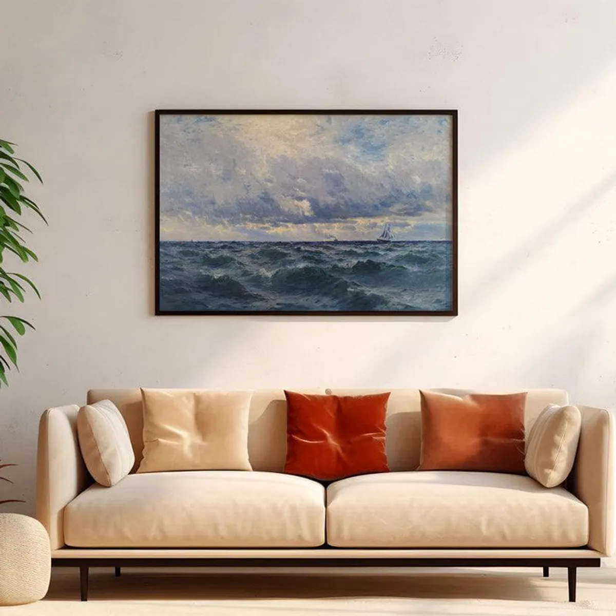 Framed ocean painting above a cream sofa with warm-toned cushions.