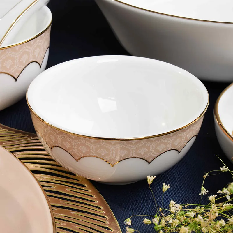 Close-up of a glossy peach and ivory porcelain bowl with gold edging