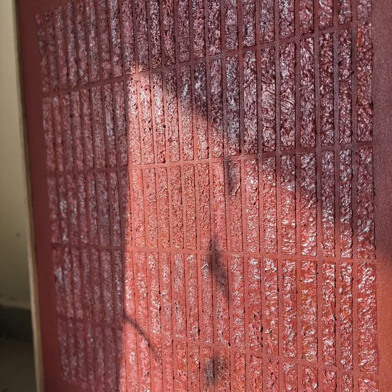 Close-up of the textured maroon surface with raised linear pattern