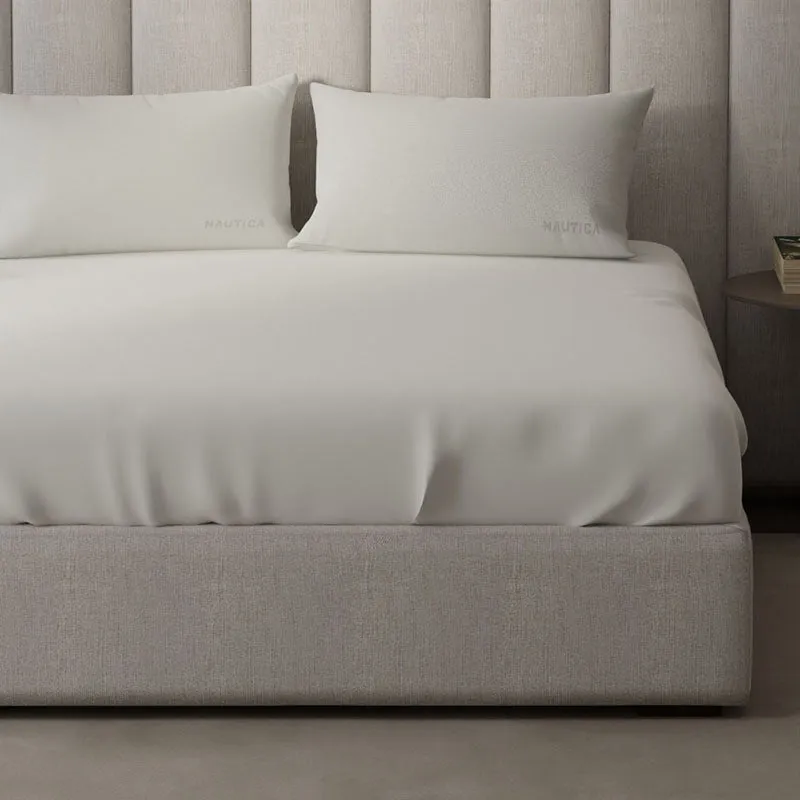 Close view of the off white bedsheet and matching pillow covers on a bed
