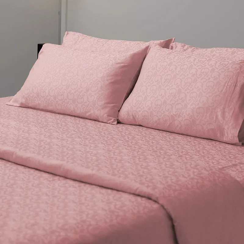 Close view of pink floral duvet cover and matching pillows on a bed