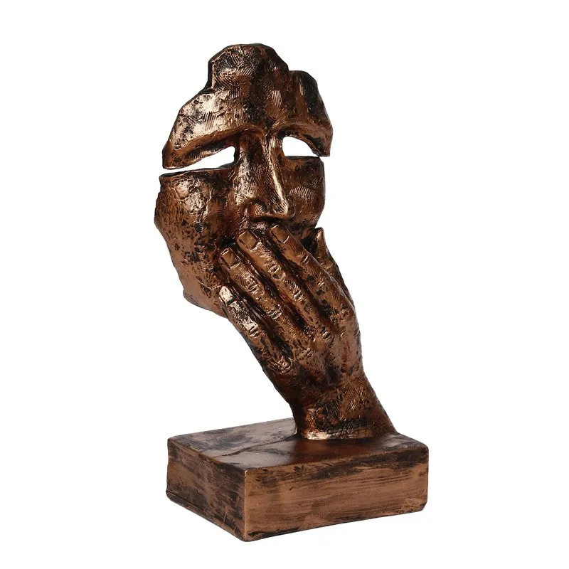 Angled view of bronze mask showpiece on a block base