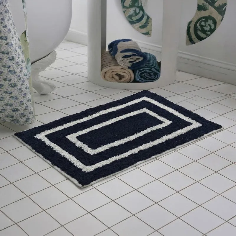 Blue and white rectangular geometric bath mat beside a toilet on tiled flooring