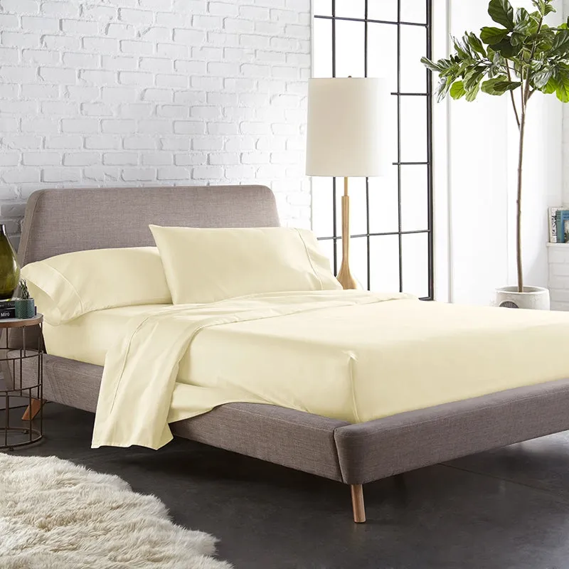 Ivory solid bedsheet set styled on a modern bed with matching pillow covers