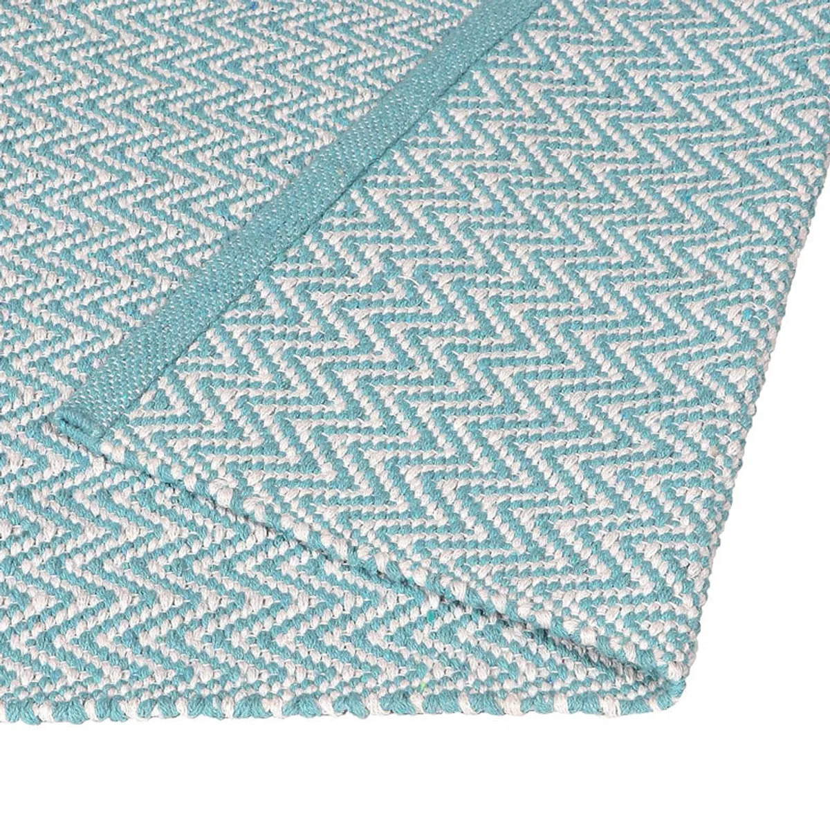 Close-up of the rug corner showing blue and white geometric weave