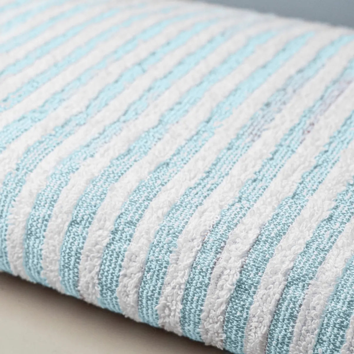 Close-up view of the towel's soft textured blue and white striped surface.