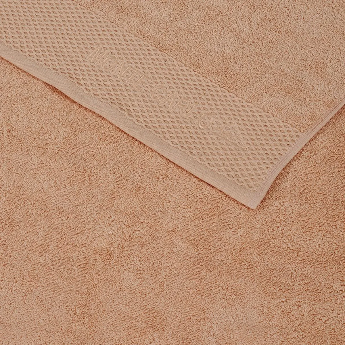 Close-up view of the towel's textured solid surface and decorative border