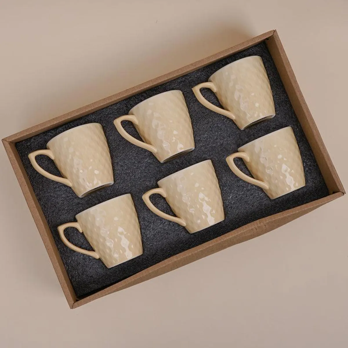 Six ivory textured tea cups arranged in a presentation box