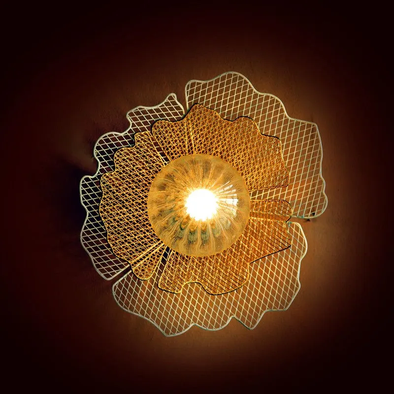 Front view of illuminated gold and white floral wall lamp