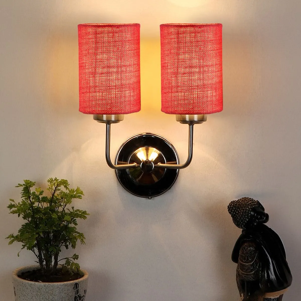 Red double-shade wall lamp glowing on a wall