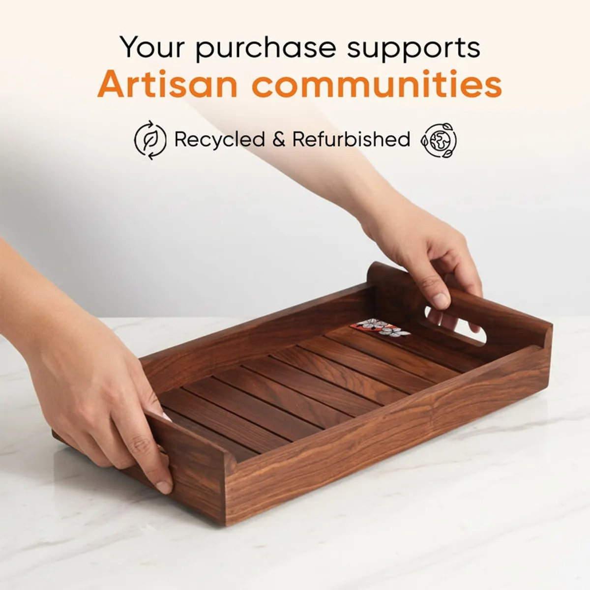 Hands carrying a brown wooden serving tray by its cut-out handles
