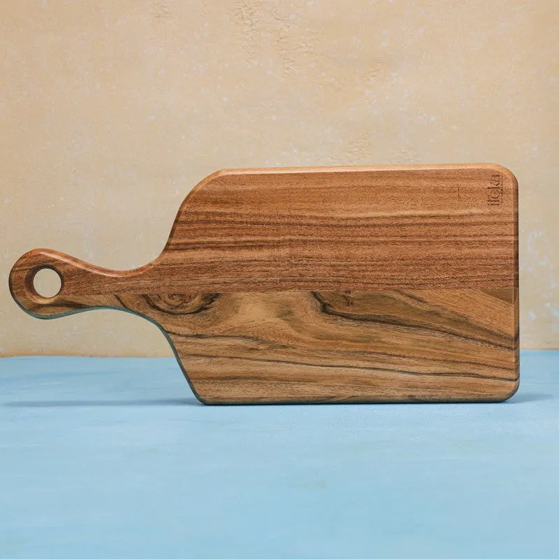 Brown Acacia wood chopping board shown from above on a blue surface