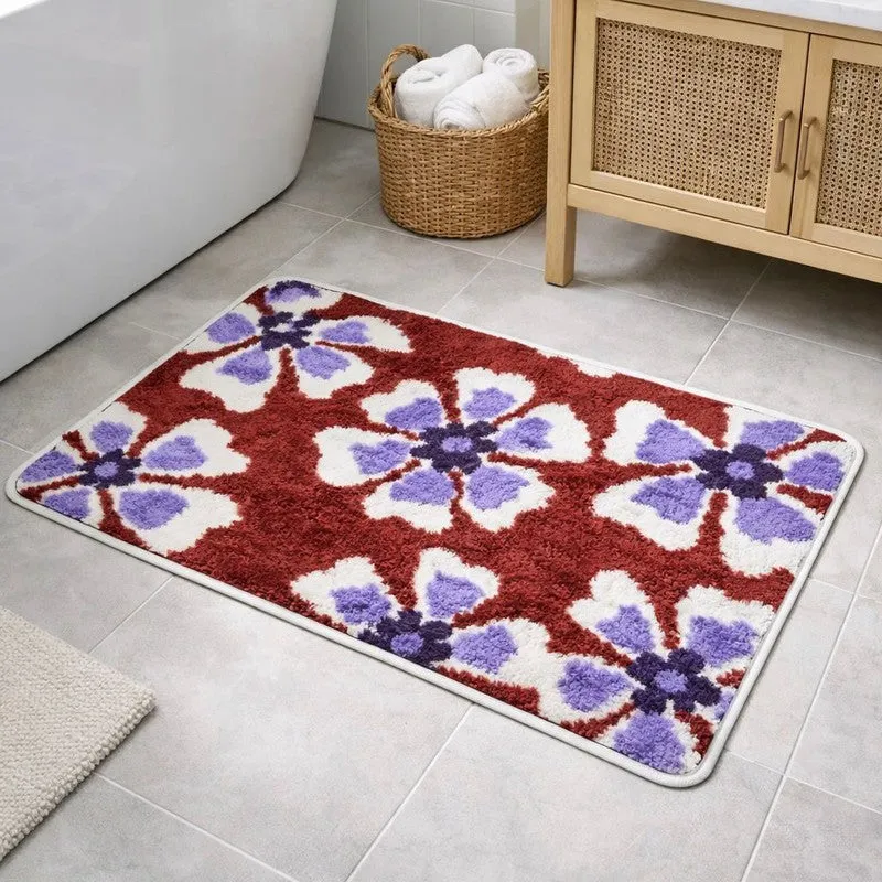 Rectangular maroon bath mat with white and purple floral pattern