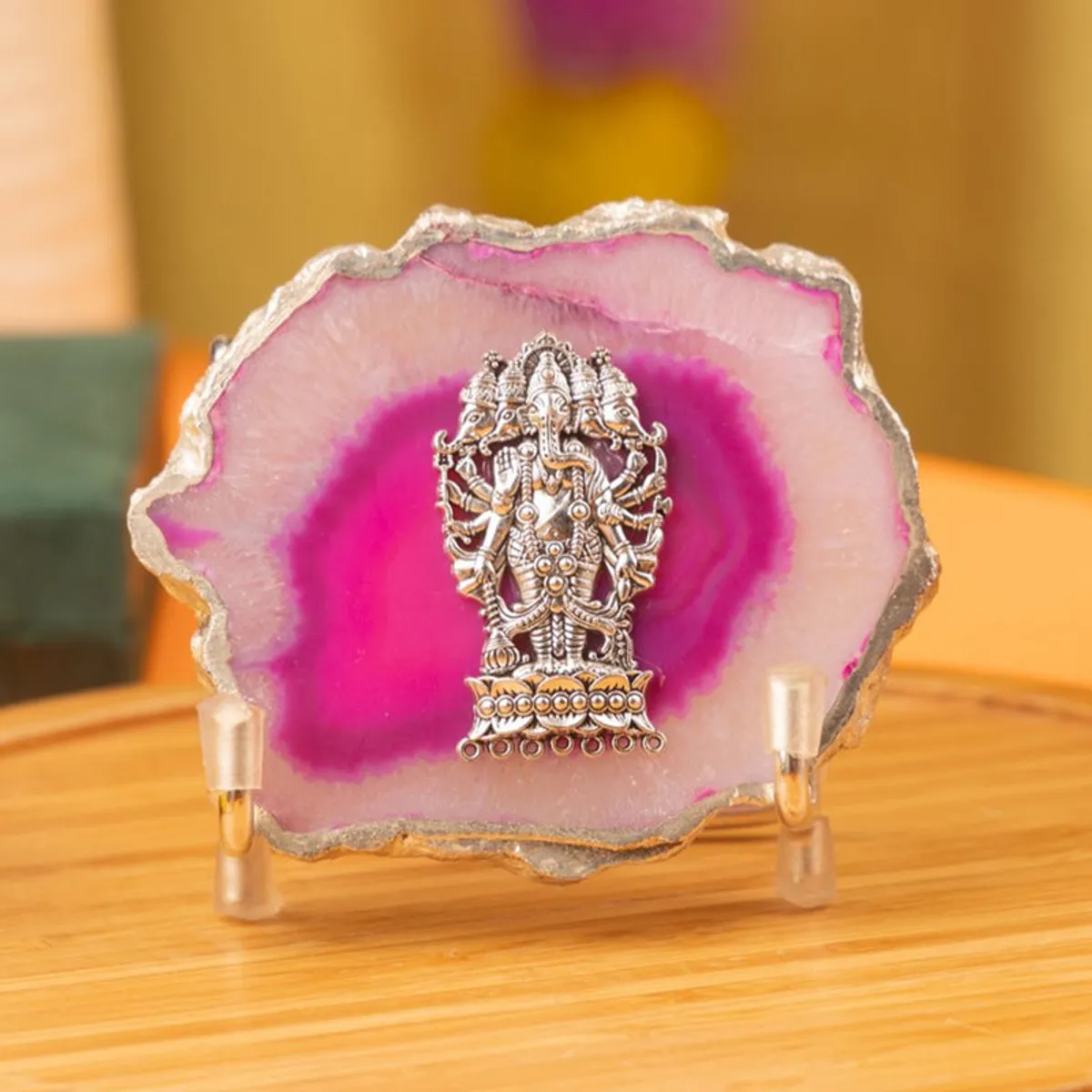 Close-up of the pink agate Ganesha showpiece on a wooden surface.
