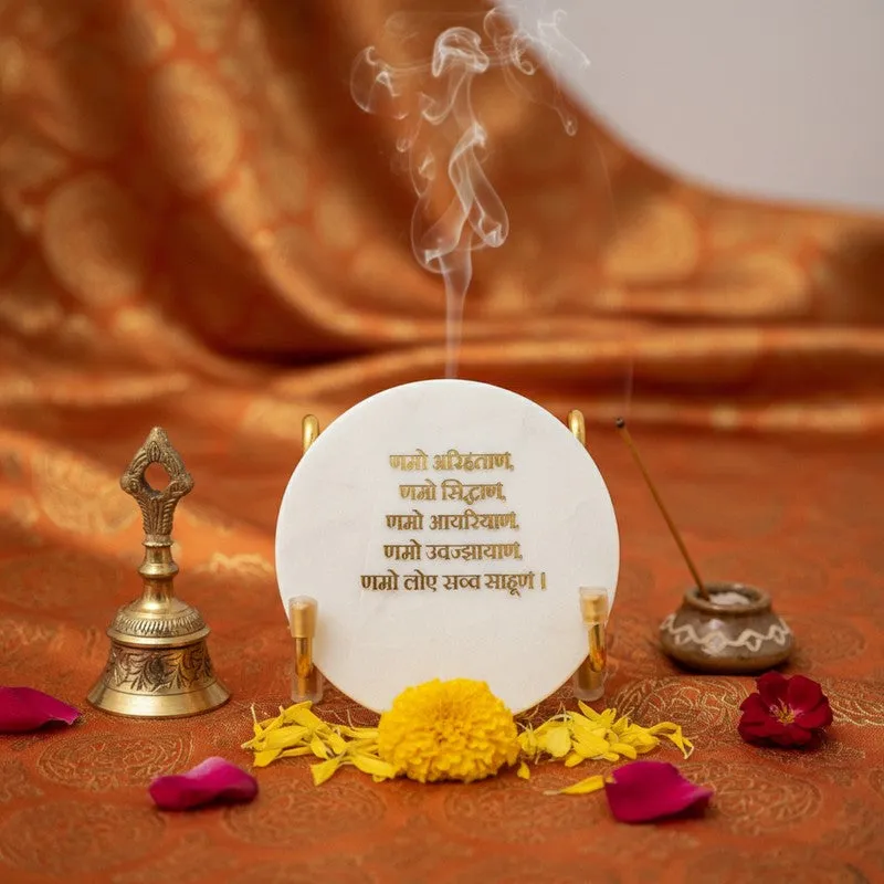White marble mantra showpiece styled with incense, flowers and brass decor