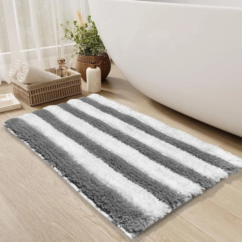 Soft grey and white striped bath mat near a bathtub