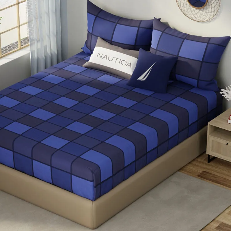 Blue checked cotton bedsheet shown on a bed with cushions
