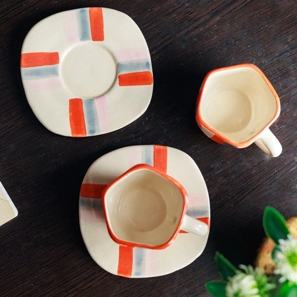 Top view of two striped cups and square-edged matching saucers