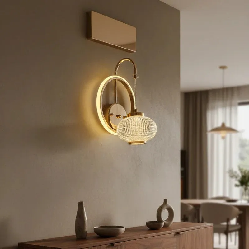 Gold and white wall lamp mounted above a wooden console in a neutral room.