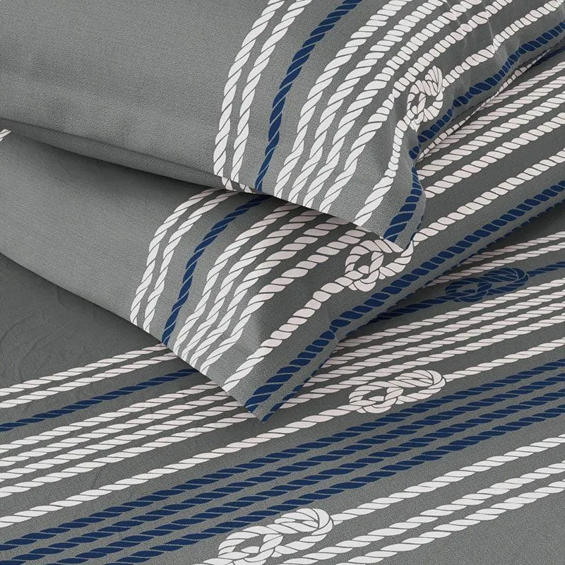 Close-up of grey bedsheet with white and blue rope-like geometric stripes