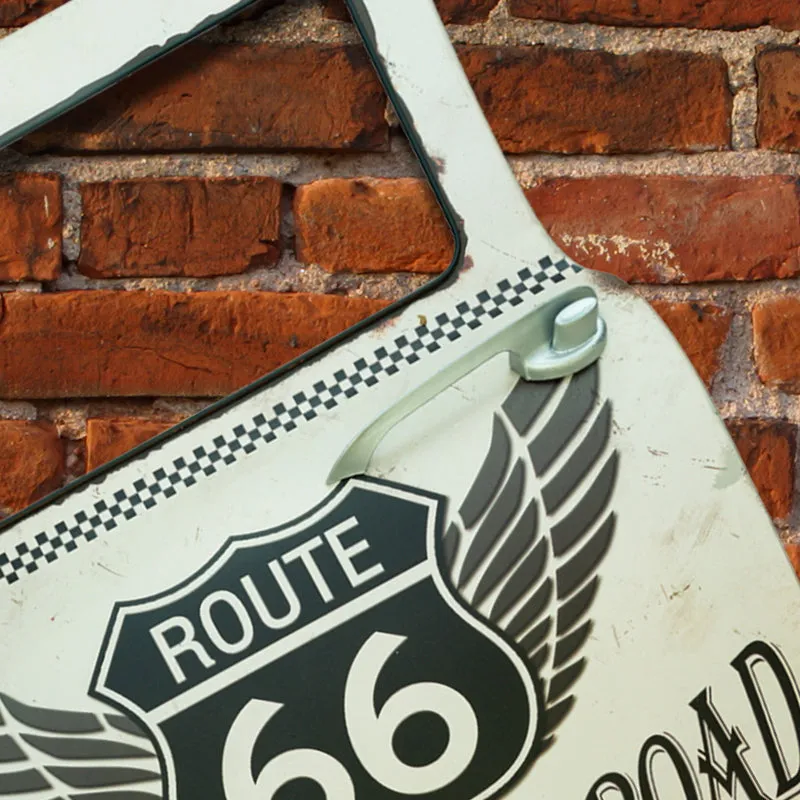 White Route 66 car-door wall accent with black wings and checkerboard detail against a brick wall