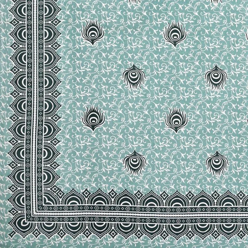 Close-up of green bedsheet with feather motifs and ornate border