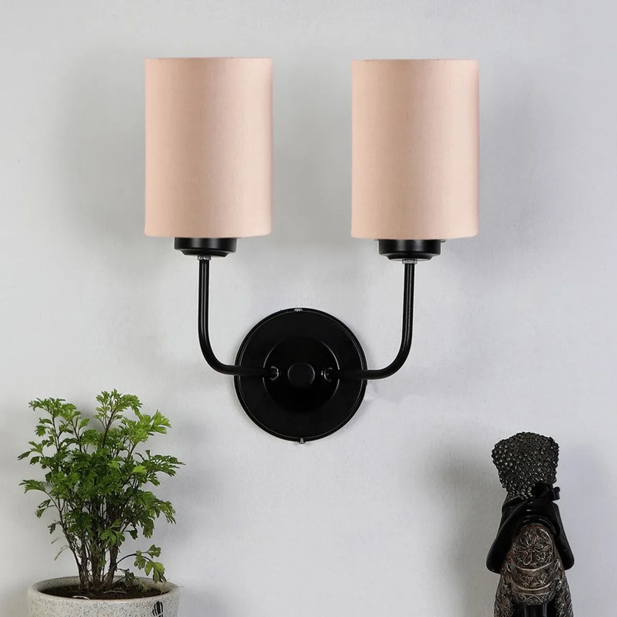 Front view of beige jute wall lamp with black iron wall mount