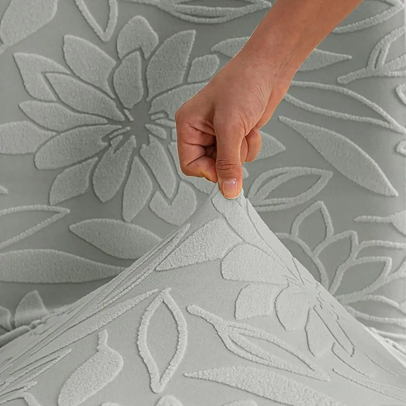 Close-up of stretchy light grey floral chair cover fabric being pulled